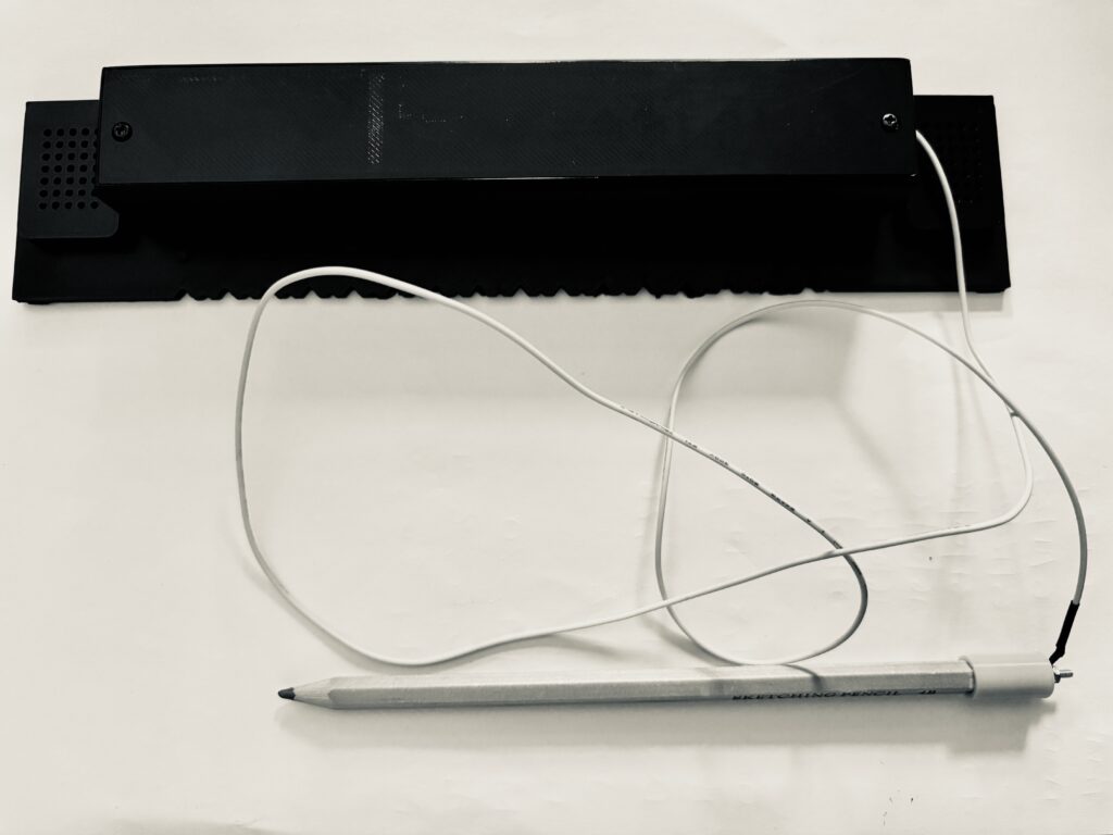 RixTalk talking ruler with pencil attached.
